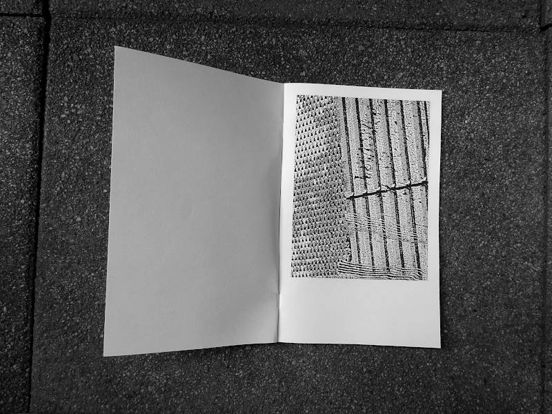 opened book with glitch monochrome images of some blindstone found at the bus stop in the city
