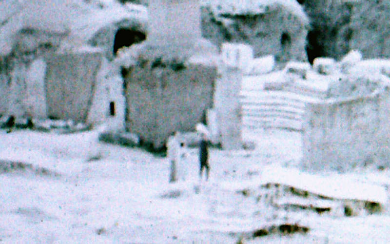 on a vintage photo some blurry people look at marble ruins