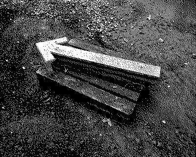 an arrow made of concrete pointing to the left. On a wooden palette in construction mud